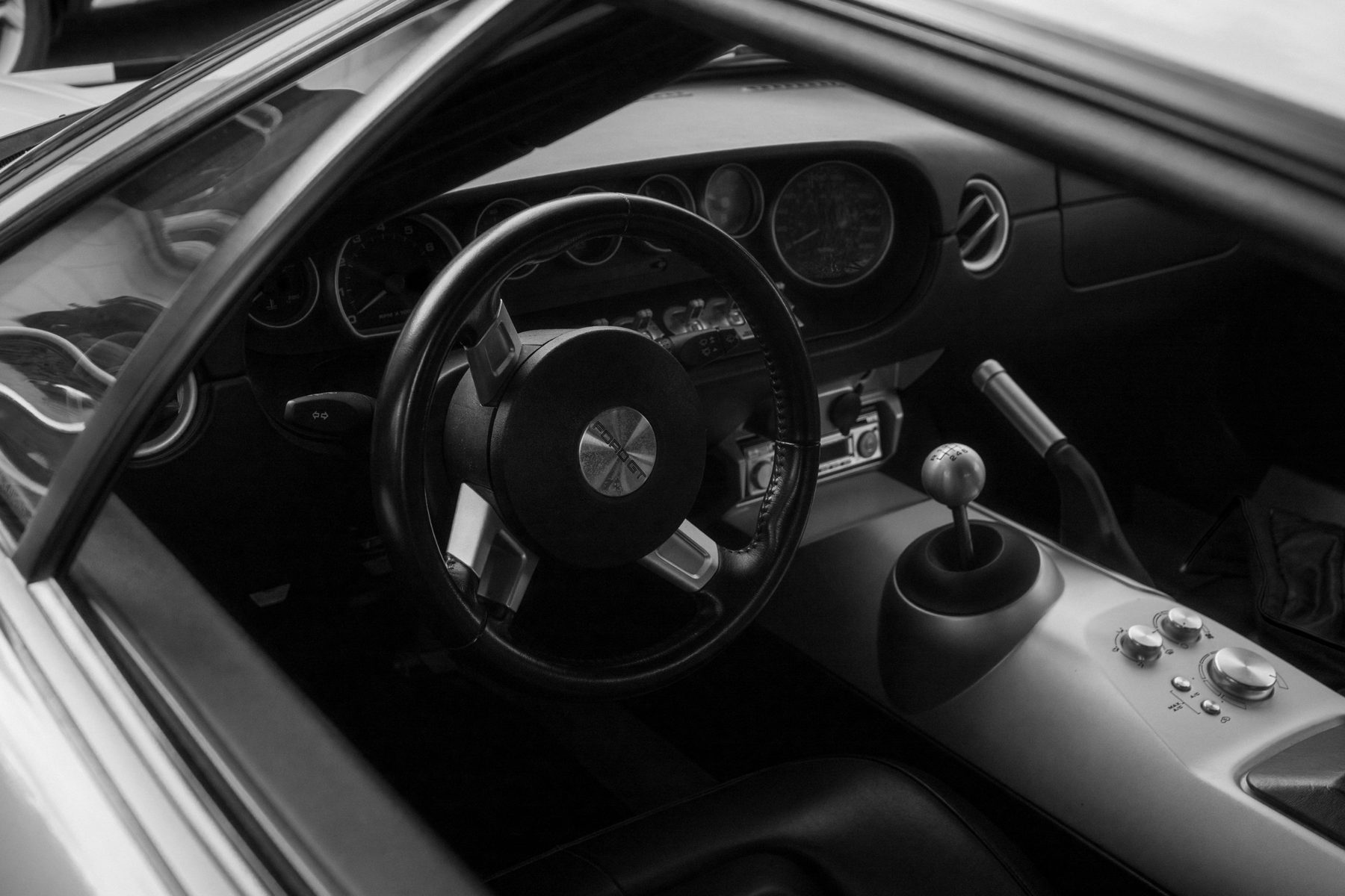 Black-and-white interior of a Ford GT: steering wheel, gauges and gear shifter